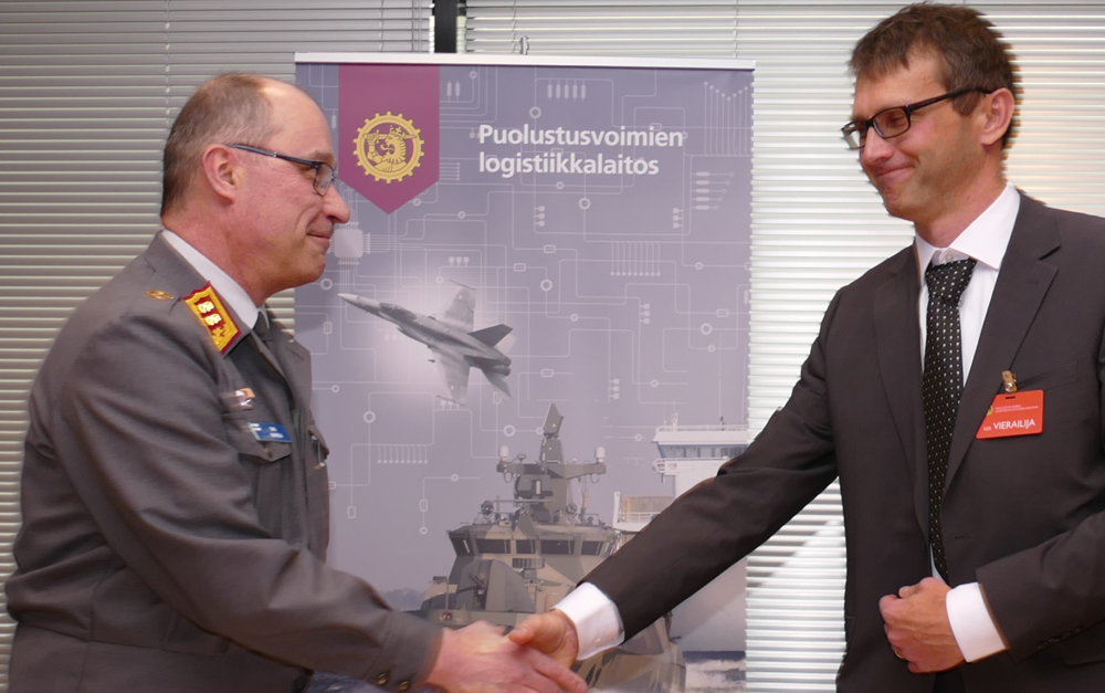 Puolustusvoimien Logistiikkalaitoksen johtaja Timo Kakkola ja Combitech Oy:n toimitusjohtaja Timo Rantala kättelevät sopimuksen allekirjoituksen päätteeksi.